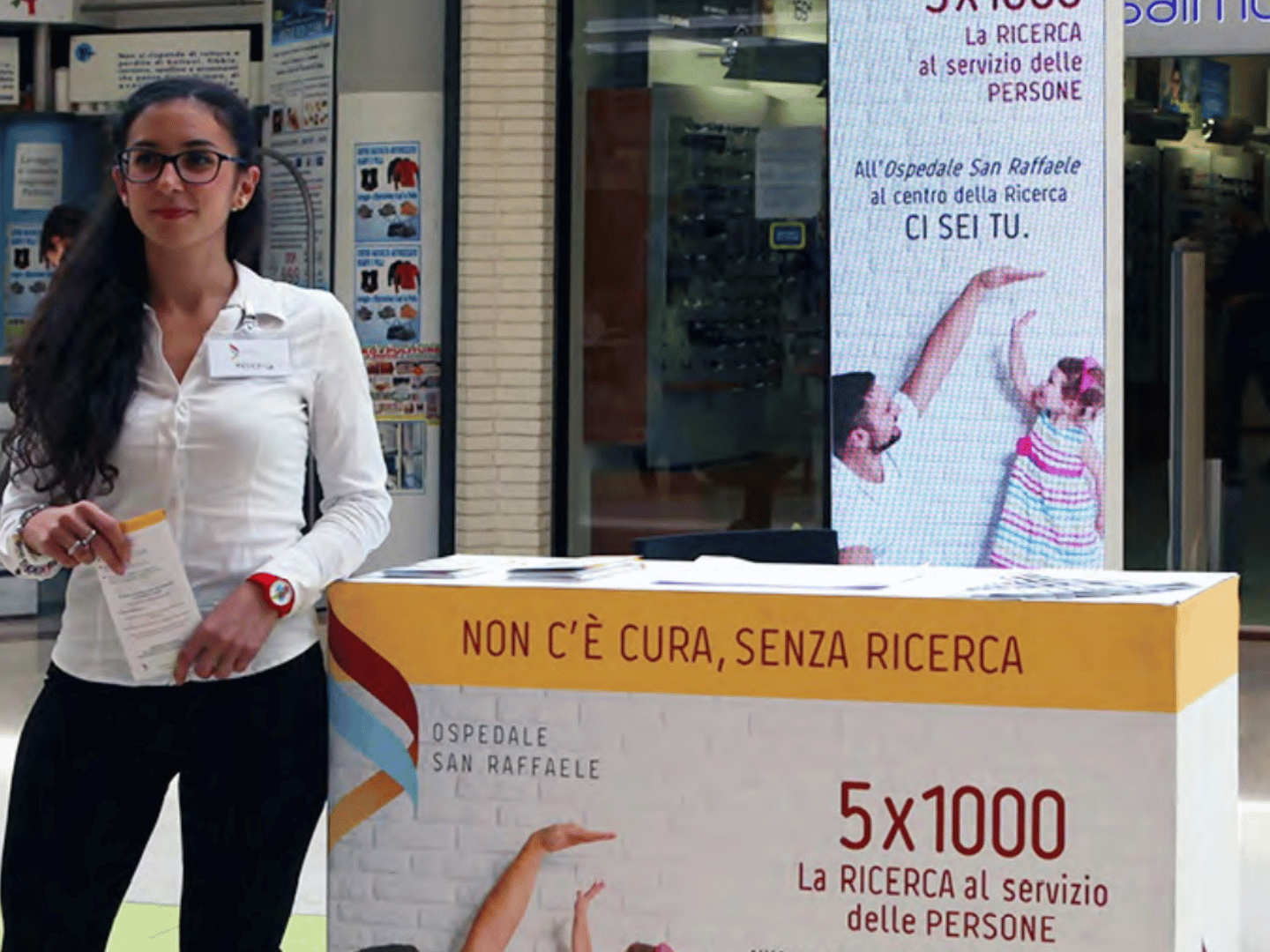 Ragazza che attende persone per illustrare un progetto in un'Area Media all'interno di un centro commerciale